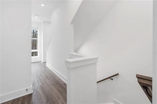 a view of hallway with stairs and wooden floor