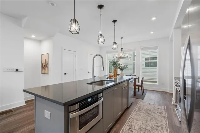 a kitchen with granite countertop a sink stainless steel appliances and cabinets
