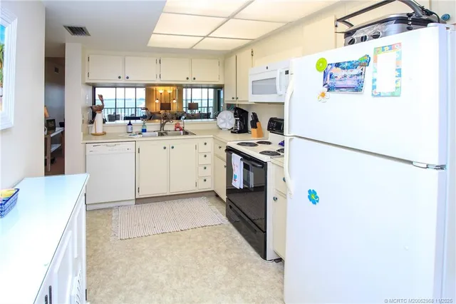 a kitchen with refrigerator and white appliances