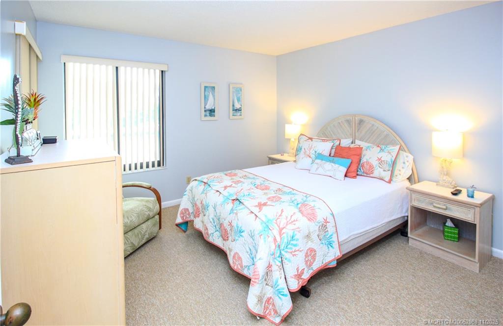4540 Northeast Sandpebble Trace, Unit 203 Stuart, FL 34996 - Photo 17 of 30 a bedroom with a bed and a window