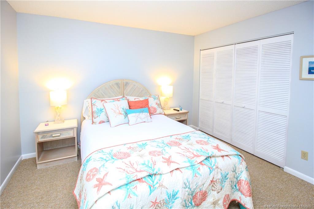 4540 Northeast Sandpebble Trace, Unit 203 Stuart, FL 34996 - Photo 18 of 30 a bedroom with a bed and a window