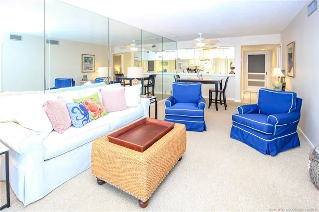a living room with furniture kitchen view and a large window