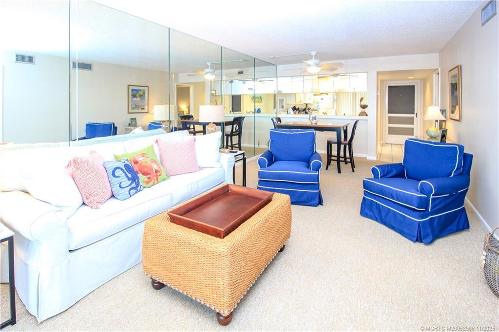 4540 Northeast Sandpebble Trace, Unit 203 Stuart, FL 34996 - Photo 9 of 30 a living room with furniture kitchen view and a large window