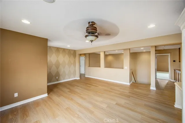 a view of an empty room with a window and wooden floor