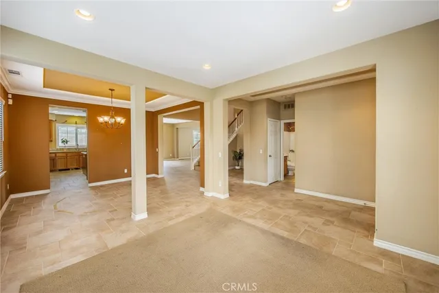 a view of a livingroom with a chandelier fan and windows