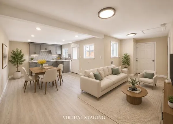 a living room with furniture kitchen view and a large window