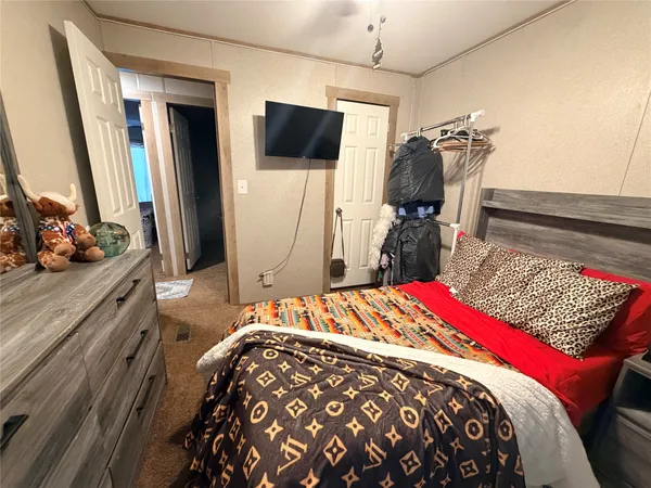 a bedroom with a bed and a flat tv screen