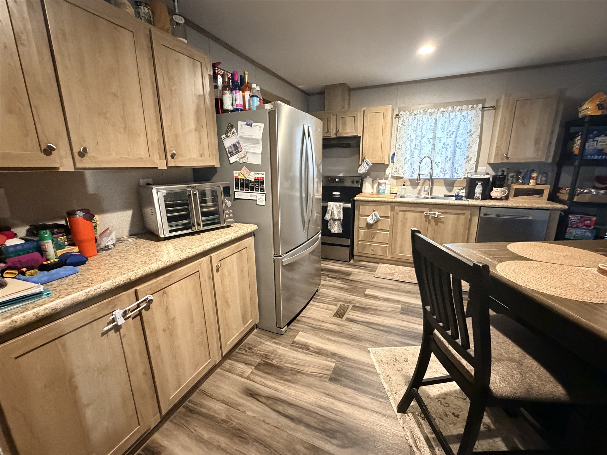 95 Westlake Road Trinity, TX 75862 - Photo 8 of 16 a kitchen with stainless steel appliances granite countertop a refrigerator a sink dishwasher a stove and white countertops with wooden floor