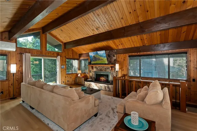 a living room with furniture a fireplace and a large window
