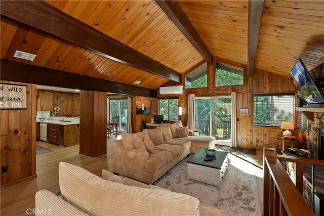 a dining room with stainless steel appliances kitchen island granite countertop a refrigerator a stove a sink with a dining table and chairs with wooden floor