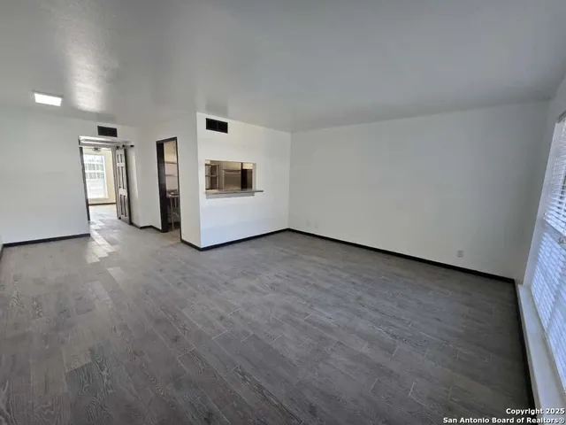 a view of a livingroom with wooden floor and a fireplace