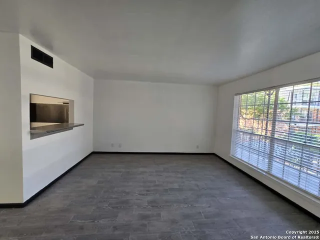a view of a livingroom with an empty space and a window
