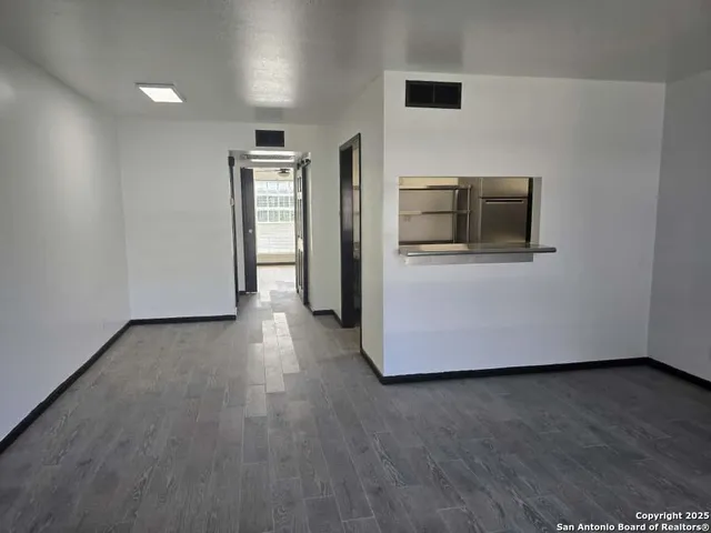 a view of a livingroom with wooden floor and electronic appliances