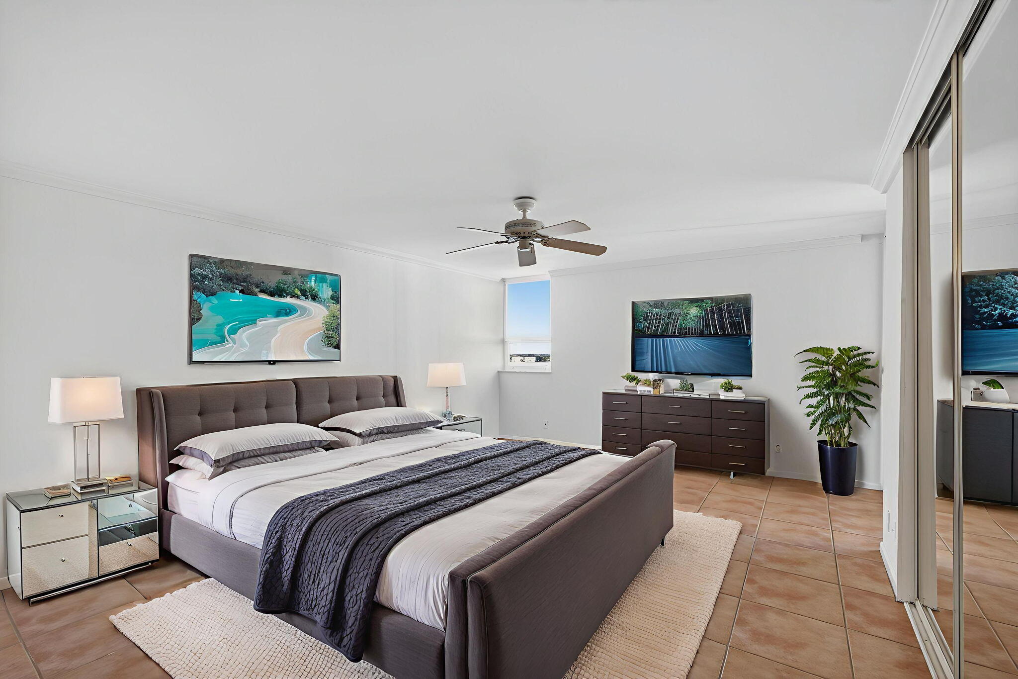 5280 North Ocean Drive, Unit 14D Riviera Beach, FL 33404 - Photo 14 of 55 a bedroom with a large bed and a flat screen tv