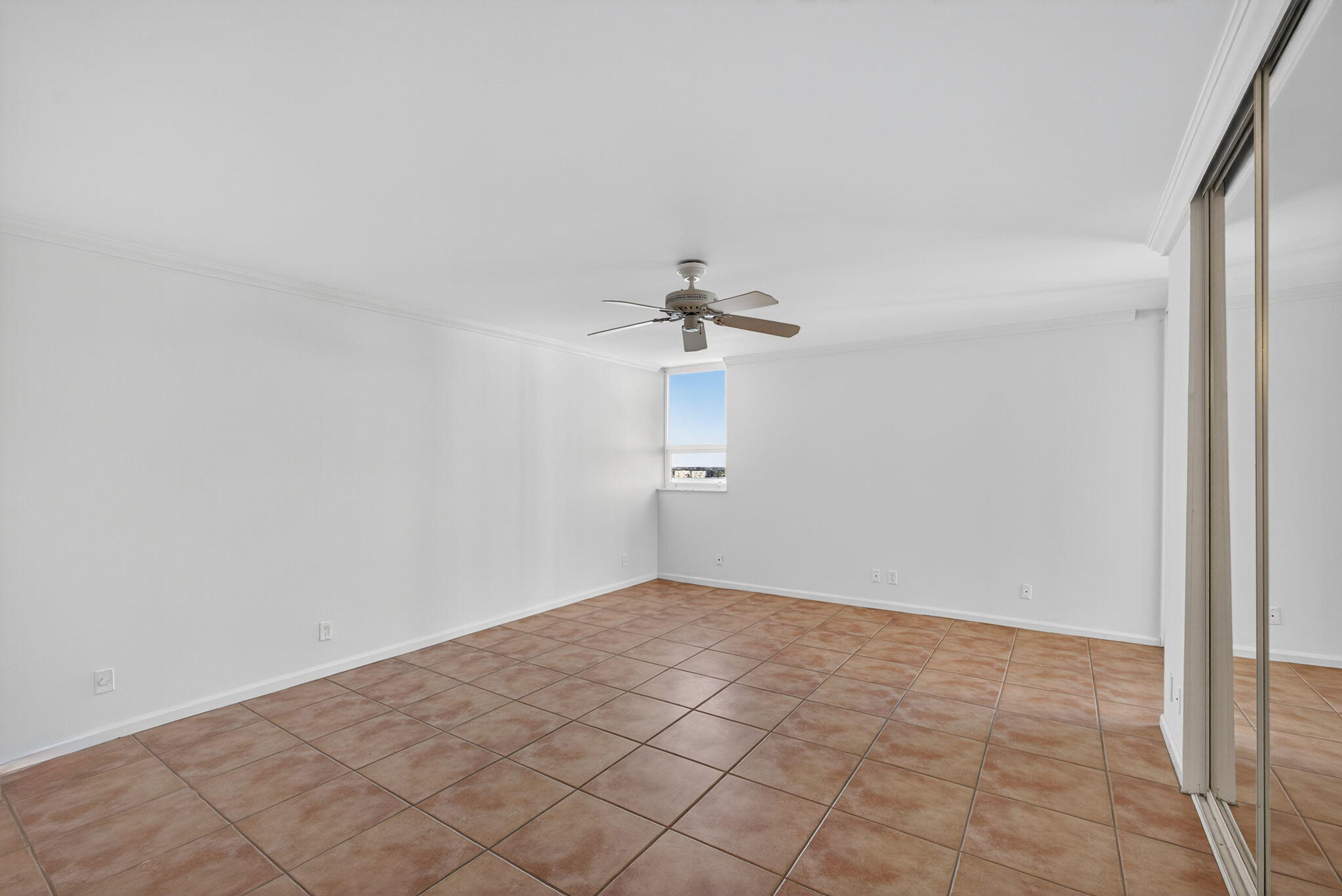 5280 North Ocean Drive, Unit 14D Riviera Beach, FL 33404 - Photo 15 of 55 an empty room with chandelier fan and windows