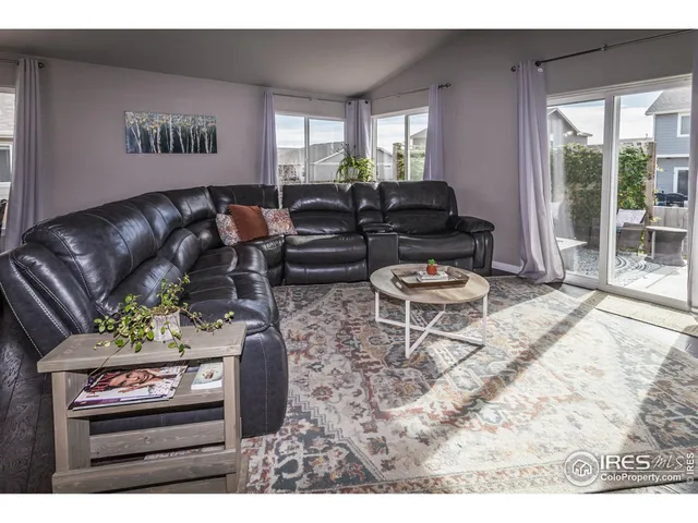 a living room with furniture a window and a flat screen tv
