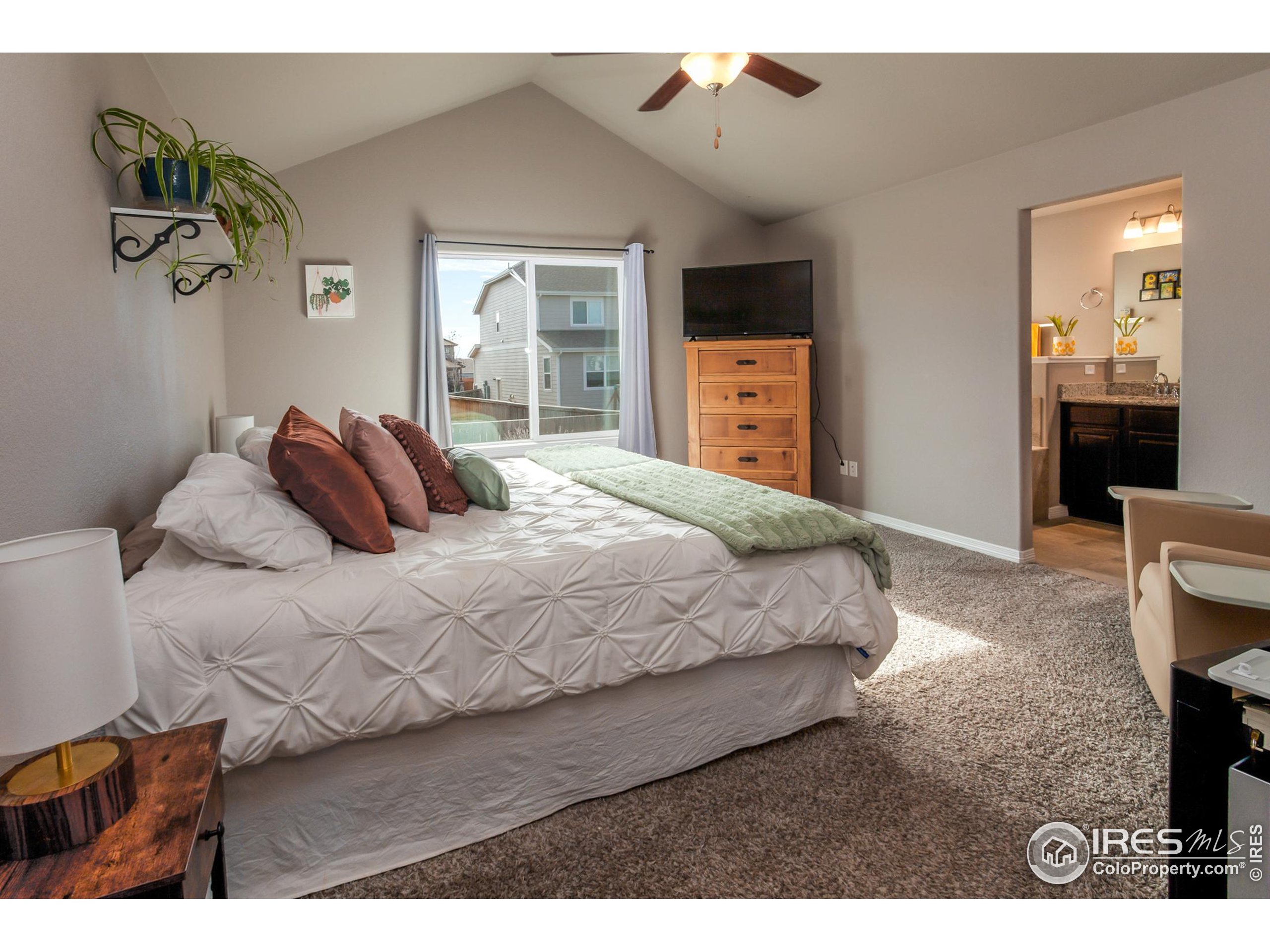 1297 Wild Basin Road Severance, CO 80550 - Photo 19 of 44 a bedroom with a bed a mirror on dresser and a dining table