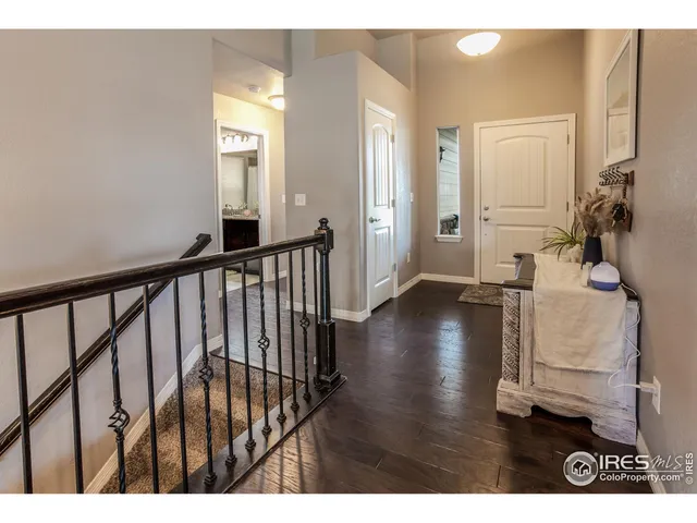 a view of a hallway with wooden floor and a living room