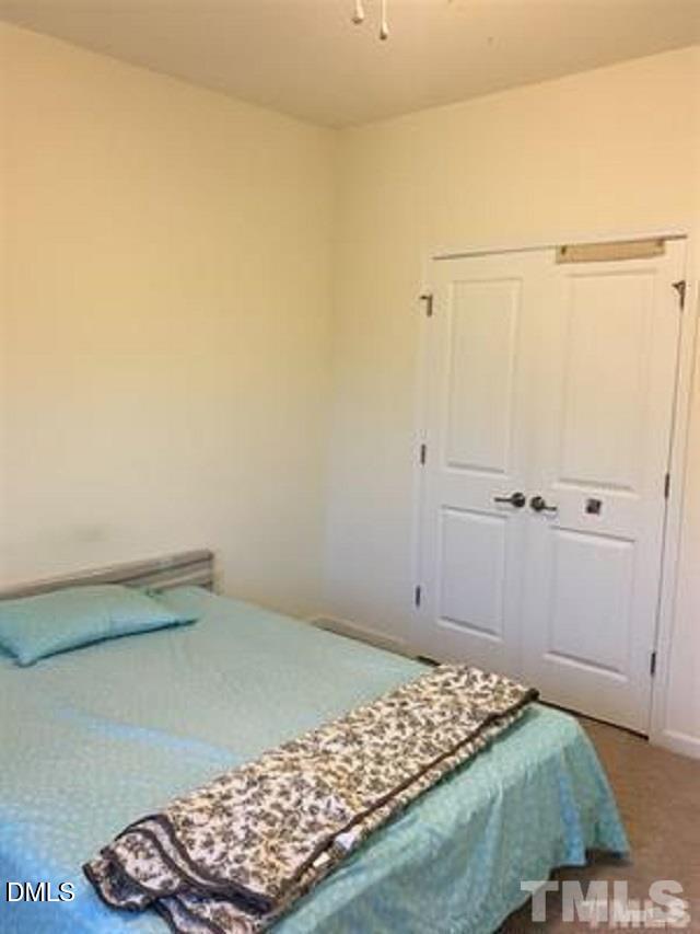 725 Edgewater Ridge Court Apex, NC 27523 - Photo 14 of 22 a bedroom with a bed and a cabinet