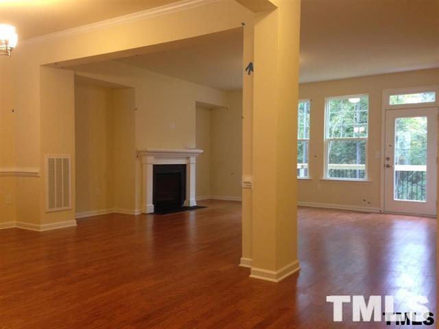 725 Edgewater Ridge Court Apex, NC 27523 - Photo 3 of 22 a view of a livingroom with wooden floor and a fireplace