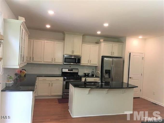 725 Edgewater Ridge Court Apex, NC 27523 - Photo 7 of 22 a kitchen with stainless steel appliances a refrigerator a sink a stove a microwave and cabinets