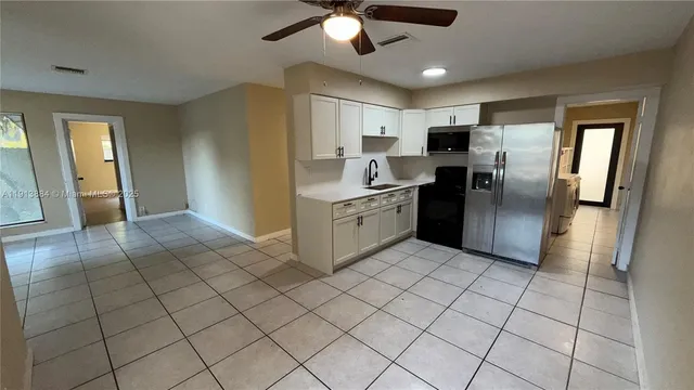 a kitchen with stainless steel appliances granite countertop a refrigerator and a sink