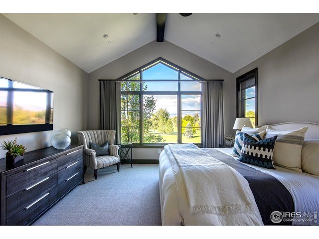 a bedroom with a bed and large windows
