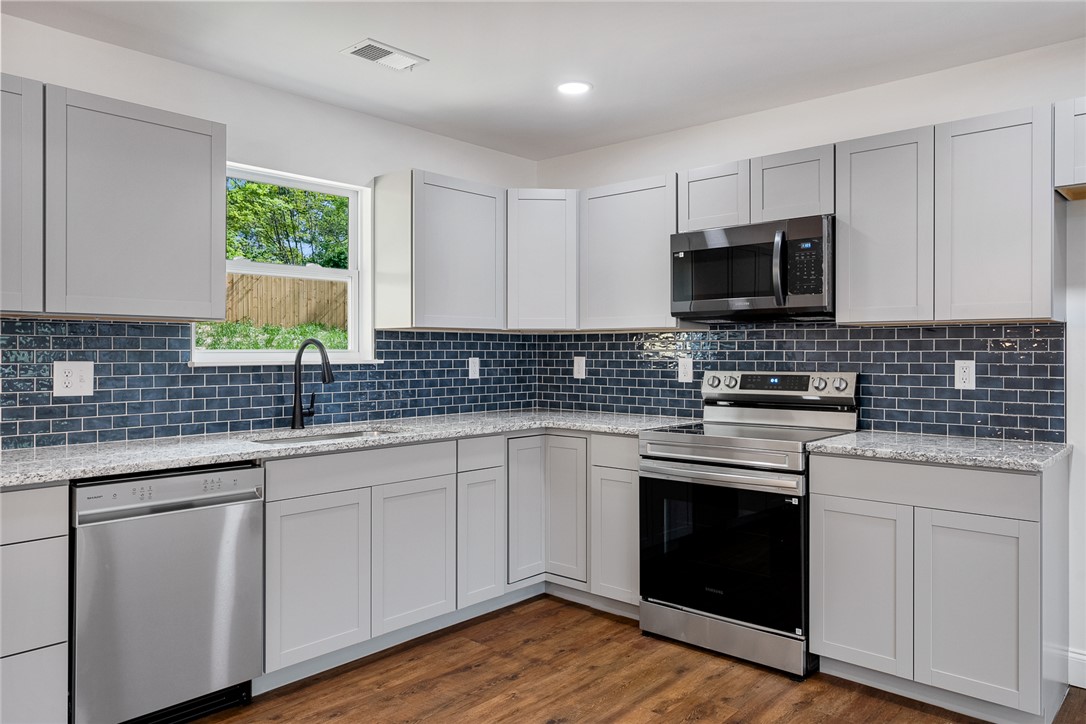 1215 East Whitner Street Anderson, SC 29624 - Photo 12 of 30 This modern kitchen features sleek appliances and ample cabinet space, perfect for culinary endeavors.