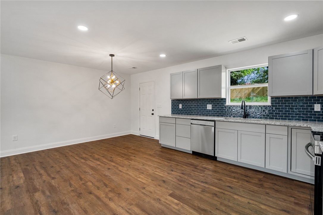 1215 East Whitner Street Anderson, SC 29624 - Photo 17 of 30 This sleek open concept kitchen and dining area features modern fixtures and durable flooring.