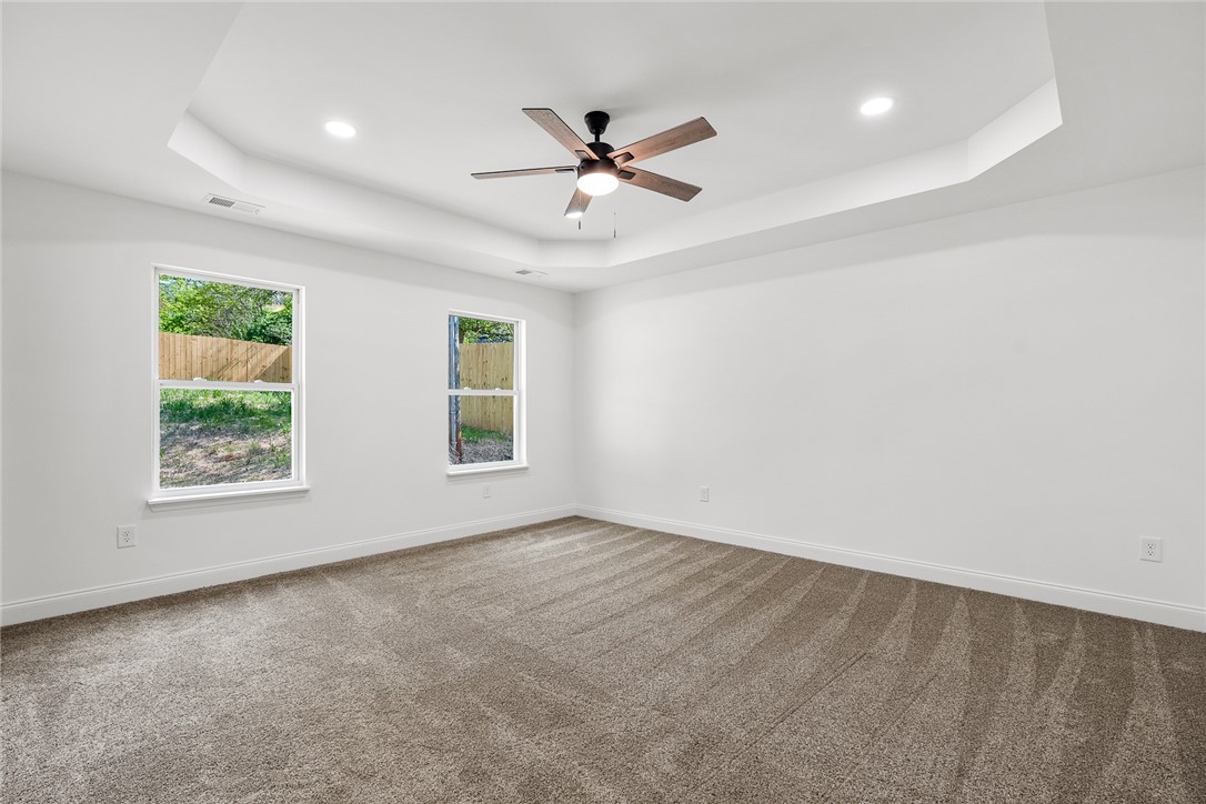 1215 East Whitner Street Anderson, SC 29624 - Photo 19 of 30 This spacious bedroom offers comfortable carpeting and elegant tray ceilings with recessed lighting.