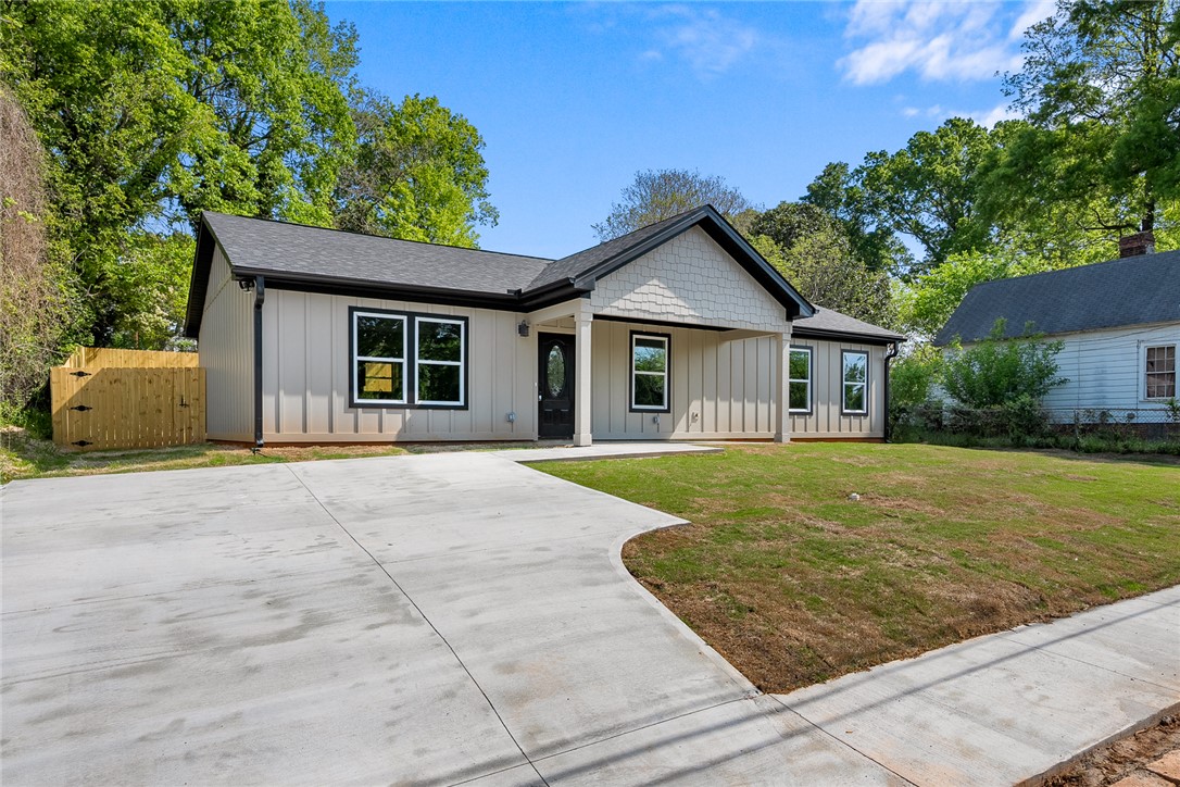 1215 East Whitner Street Anderson, SC 29624 - Photo 2 of 30 This newly constructed home presents a contemporary facade with a neatly landscaped lawn and a spacious driveway.