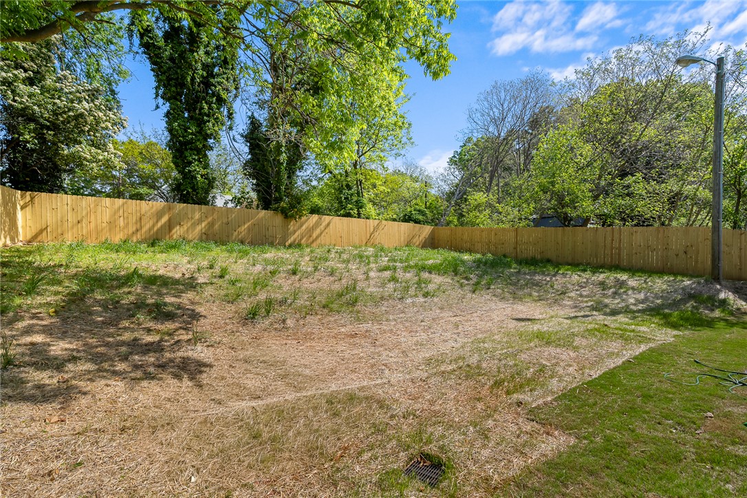 1215 East Whitner Street Anderson, SC 29624 - Photo 30 of 30 A spacious backyard awaits your creative vision, enclosed by a privacy fence.