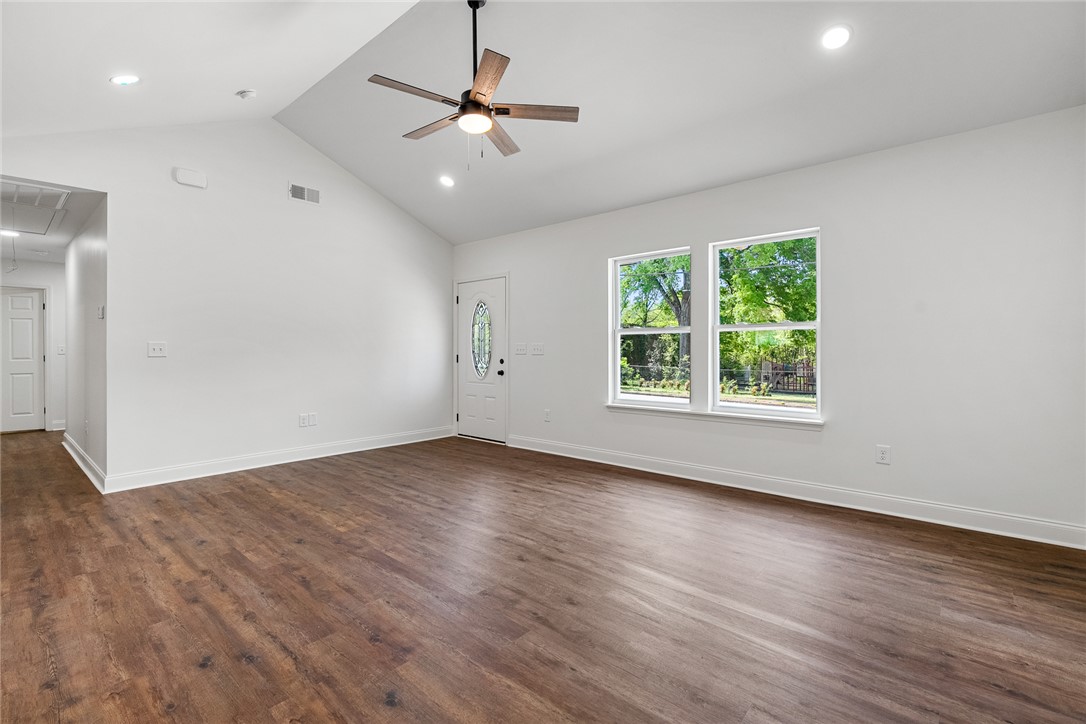 1215 East Whitner Street Anderson, SC 29624 - Photo 9 of 30 This living area features a soaring vaulted ceiling and durable hardwood flooring.