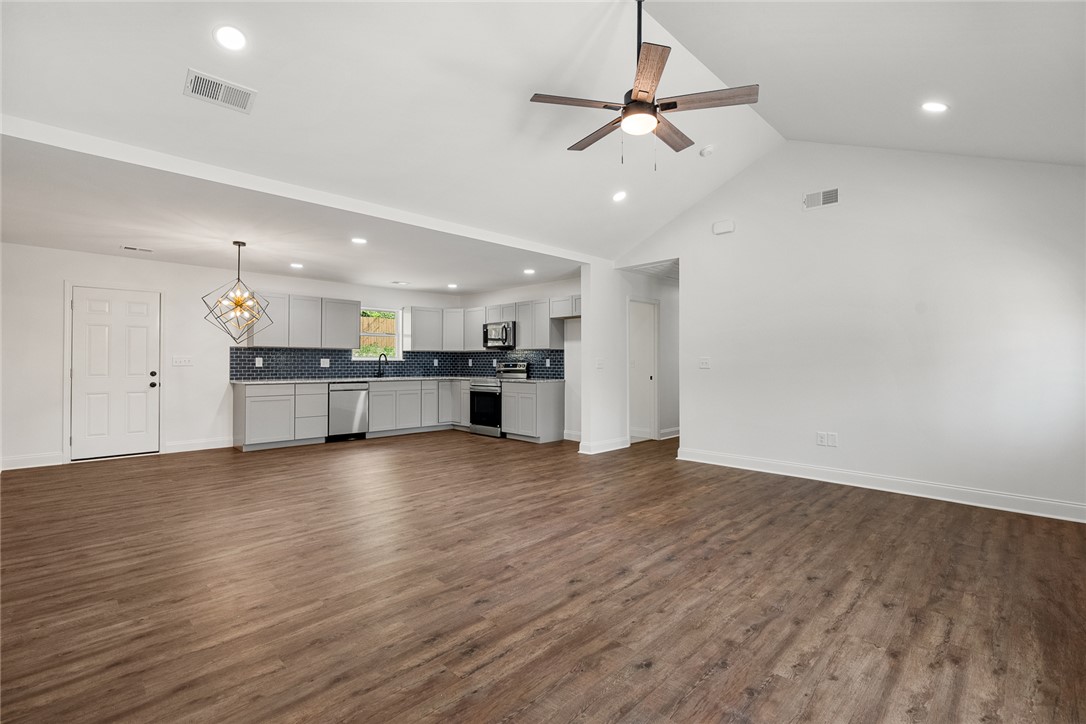 1215 East Whitner Street Anderson, SC 29624 - Photo 10 of 30 This bright, open concept living area seamlessly integrates a modern kitchen, featuring vaulted ceilings and sleek flooring.