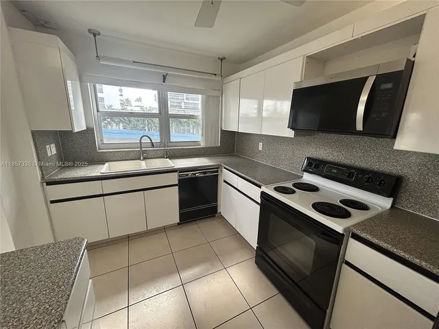 a kitchen with a sink stove top oven and cabinets