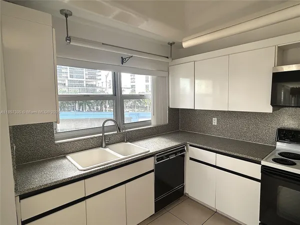 a kitchen with granite countertop a sink and a stove