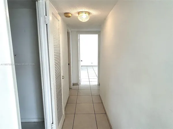 a view of a hallway with wooden floor and a window