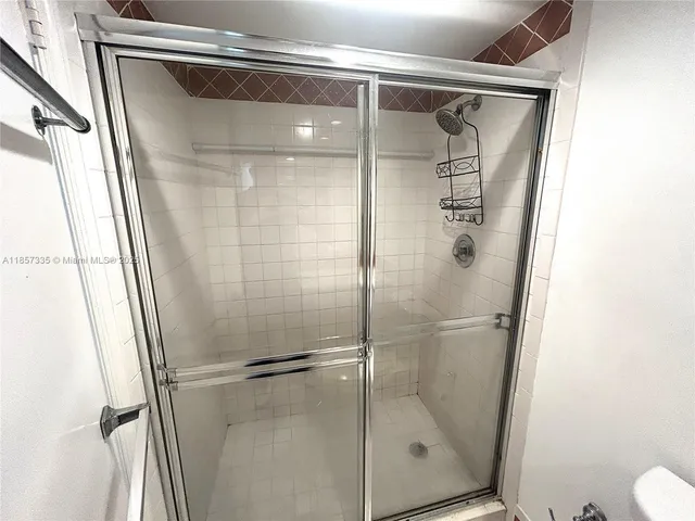 a bathroom with a glass door shower and toilet