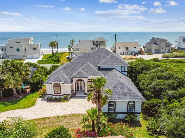 a aerial view of a house with a big yard plants and large tree