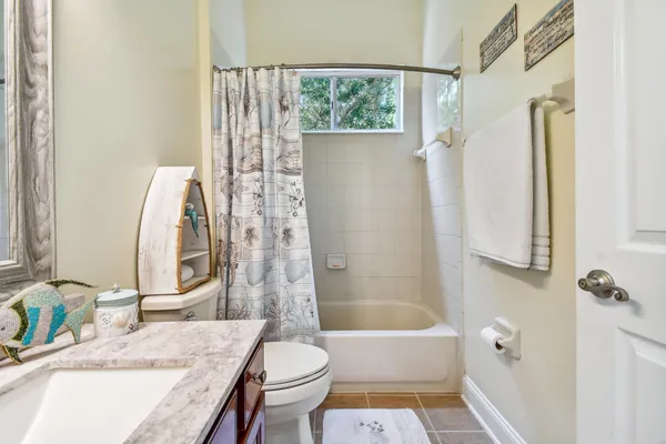 a bathroom with a granite countertop sink a mirror and a shower