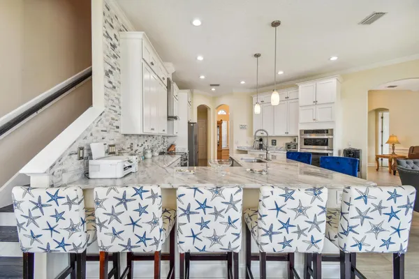 a kitchen with stainless steel appliances kitchen island granite countertop a stove a sink and a refrigerator