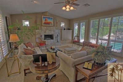 49145 Rio Arenoso La Quinta, CA 92253 - Photo 3 of 18 a living room with furniture a chandelier and a fireplace