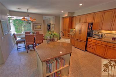 49145 Rio Arenoso La Quinta, CA 92253 - Photo 7 of 18 a kitchen with stainless steel appliances granite countertop sink microwave and wooden floor