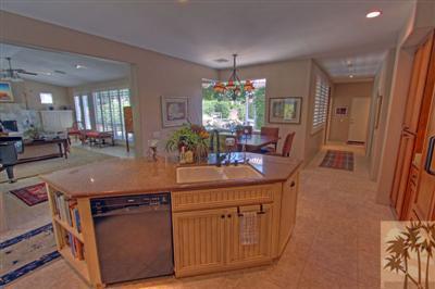 49145 Rio Arenoso La Quinta, CA 92253 - Photo 8 of 18 a kitchen with stainless steel appliances granite countertop a sink a stove a dining table and chairs