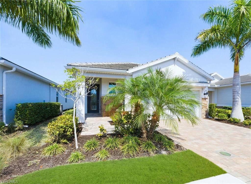 View of front of home featuring an attached garage, stucco siding, and decorative driveway