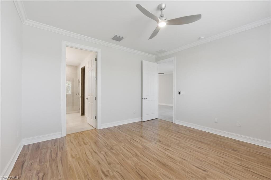 28310 Captiva Shell Loop Bonita Springs, FL 34135 - Photo 14 of 44 Unfurnished bedroom featuring a ceiling fan, crown molding, light wood-style flooring, and connected bathroom