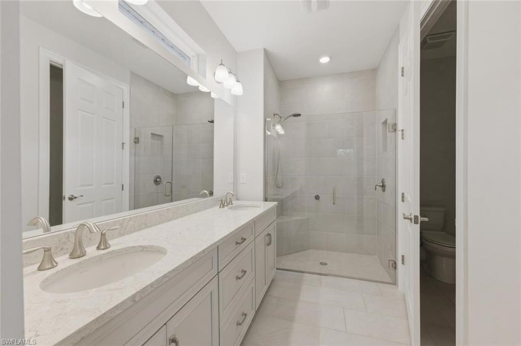 28310 Captiva Shell Loop Bonita Springs, FL 34135 - Photo 15 of 44 Full bathroom featuring double vanity, a shower stall, light tile patterned floors, and recessed lighting