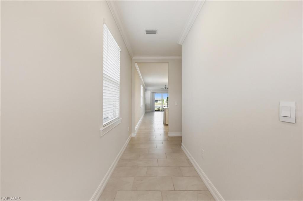 28310 Captiva Shell Loop Bonita Springs, FL 34135 - Photo 2 of 44 Hallway featuring crown molding and light tile patterned flooring