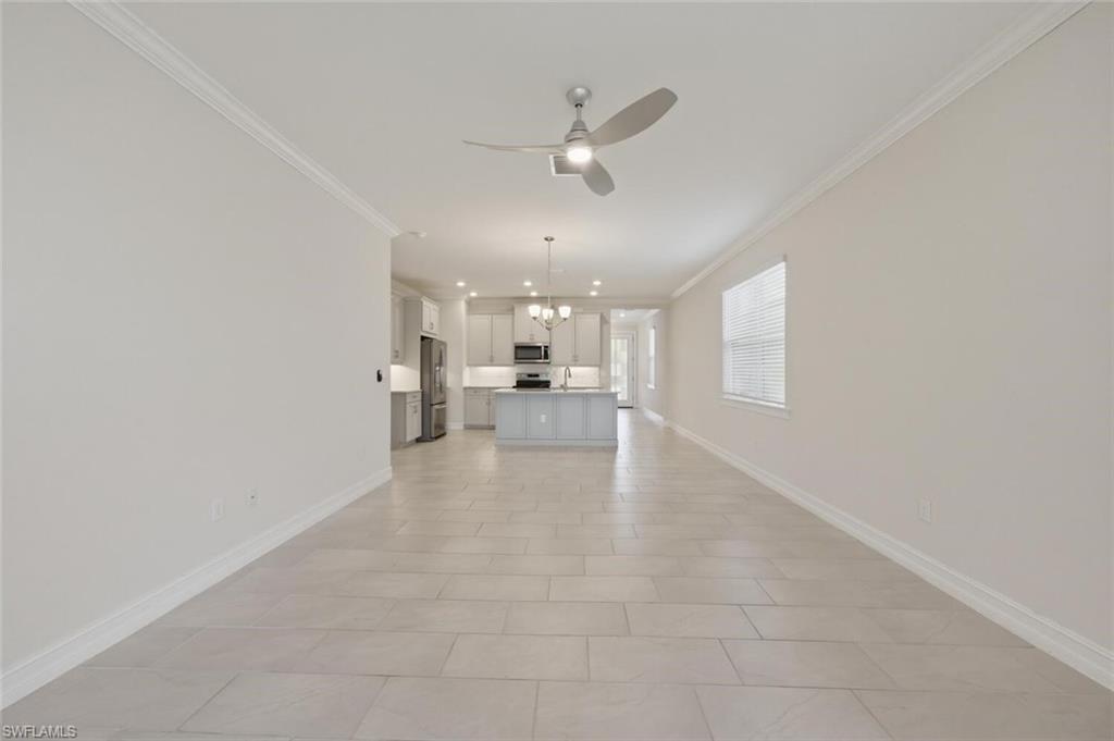 28310 Captiva Shell Loop Bonita Springs, FL 34135 - Photo 5 of 44 Unfurnished living room featuring a chandelier, ceiling fan, and crown molding
