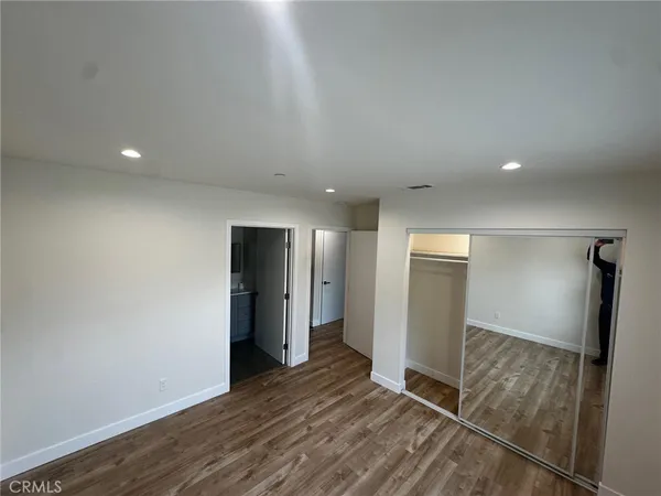 a view of an empty room with closet and a window
